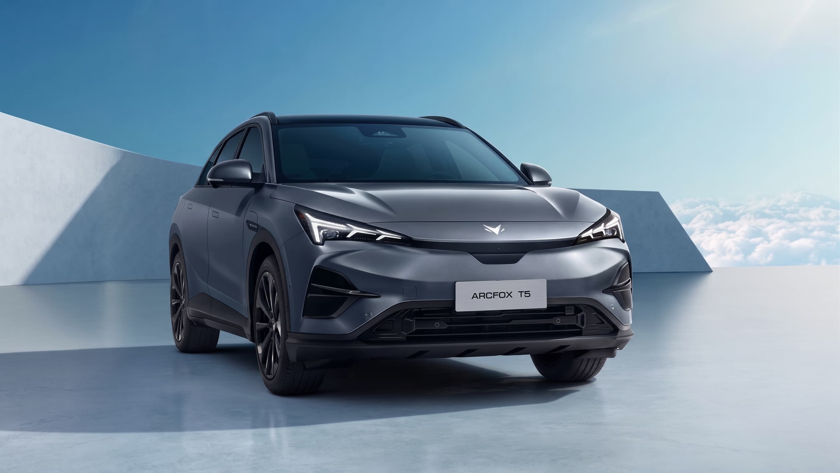 SUV grafite em estúdio, visto de três quartos dianteiro, sobre piso claro e fundo azul
